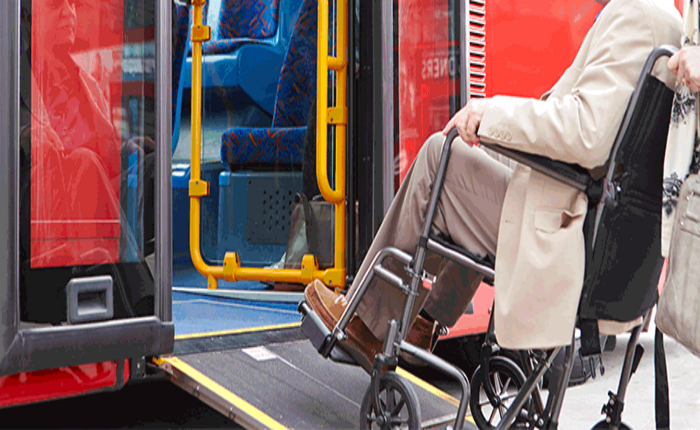 Femme en fauteuil montant une rampe de bus