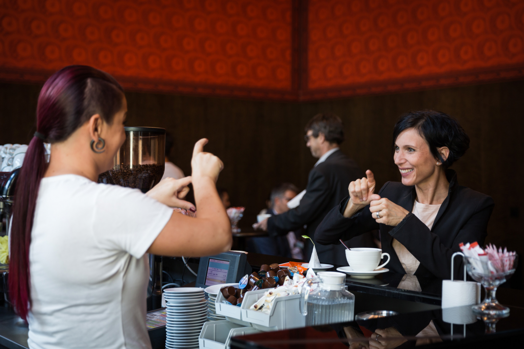 Deux femmes discutant en Langue des signes autour d'un café