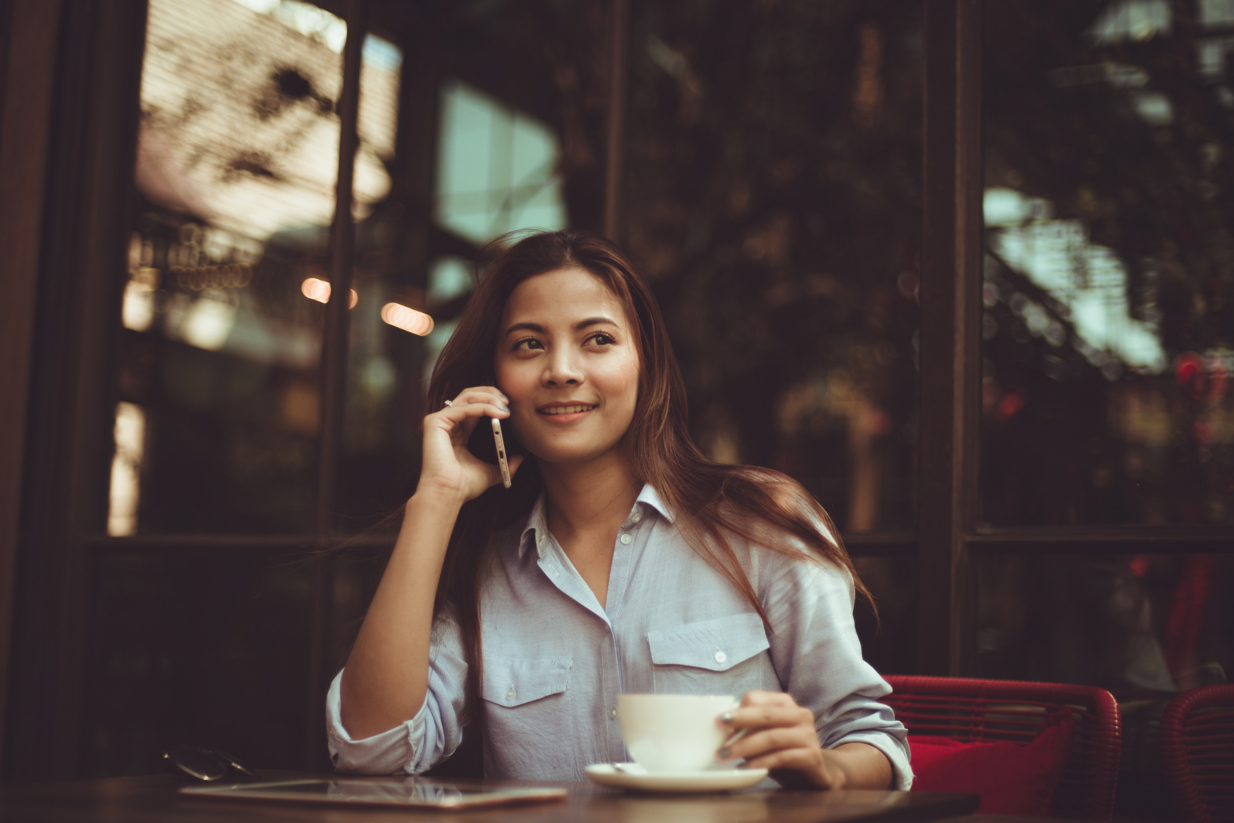Femme téléphonant à un café