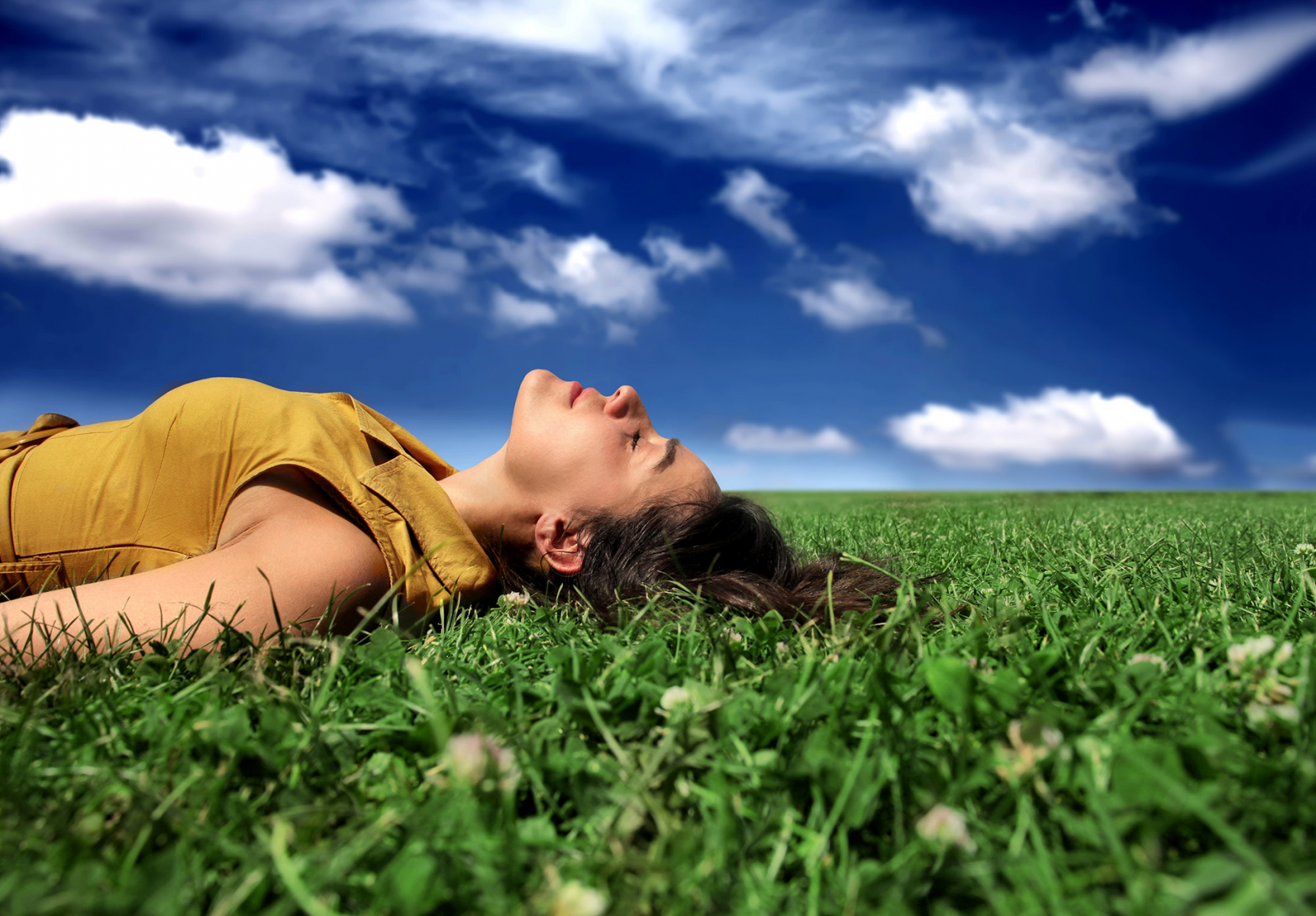 Femme se reposant allongée dans l'herbe