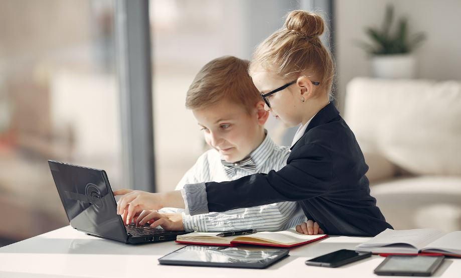 Deux enfants s'aidant face à un ordinateur