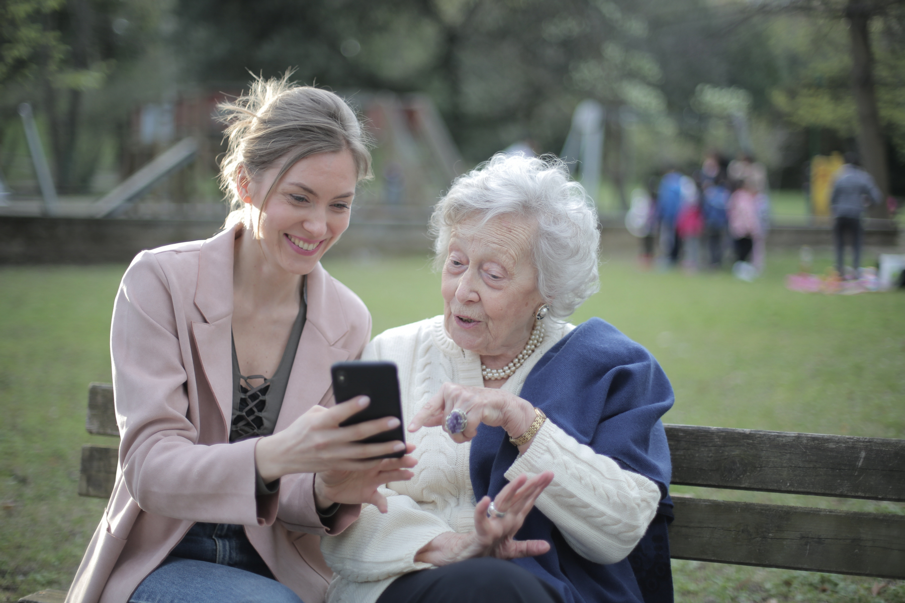 Femme aidant une personne âgée sur son téléphone