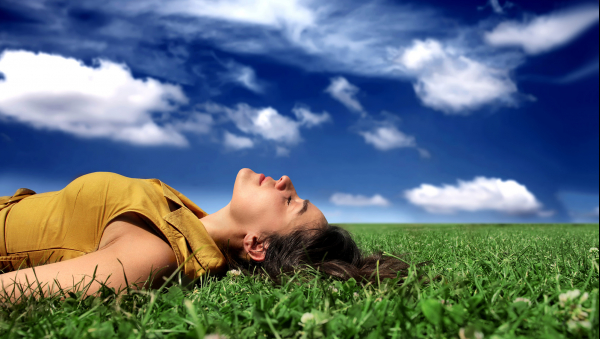 Femme se reposant allongée dans l'herbe